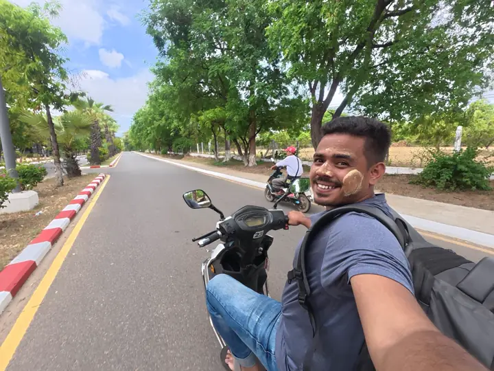 Saif Afrisian riding an electric scooter in Bagan with thanaka on his cheeks
